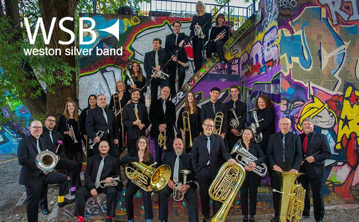 Photo of Weston Silver Band in front of graffiti painted wall. 